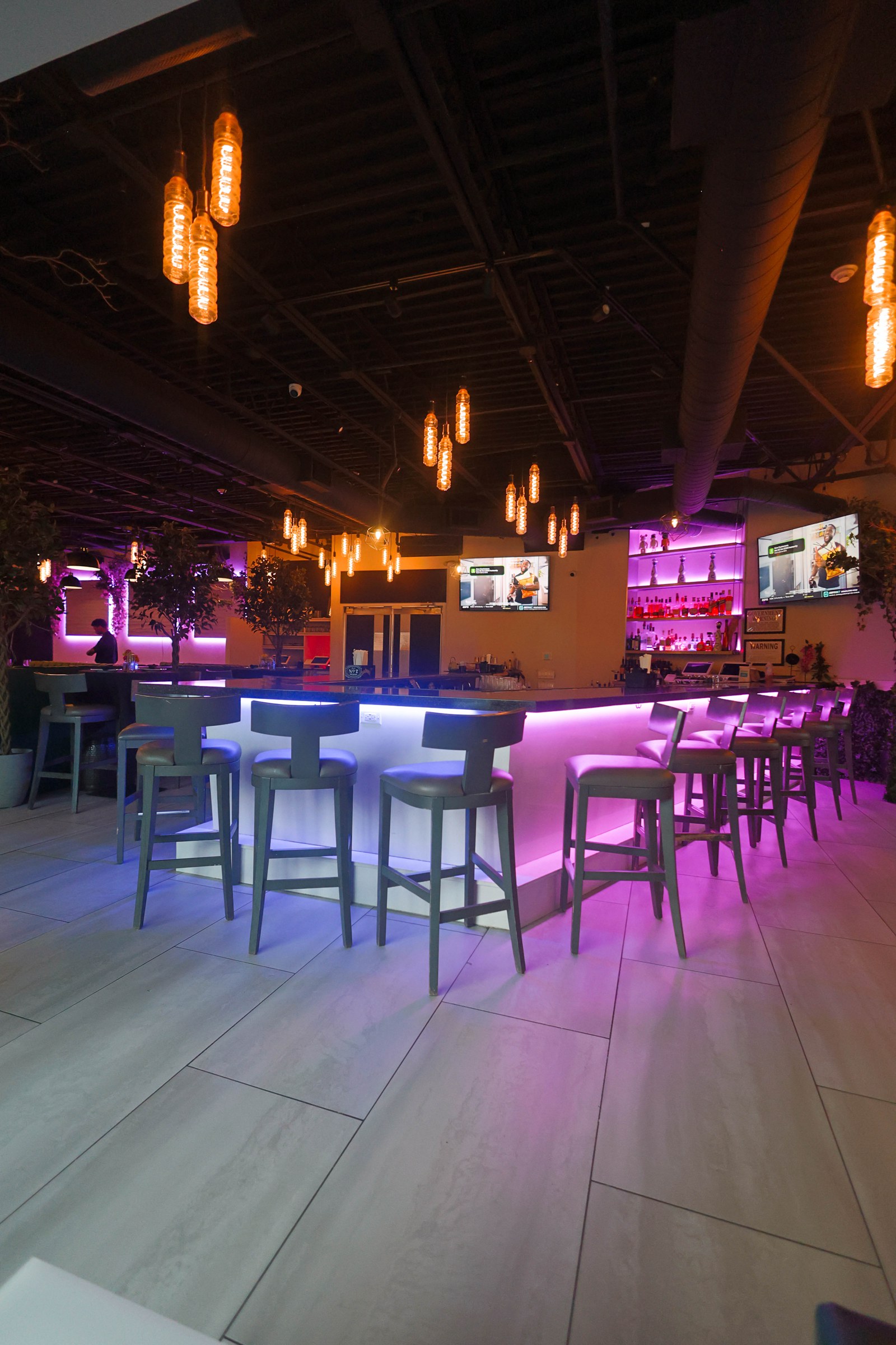 Ivy bar with glowing counter and pendant lights